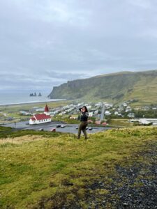 Katie standing above the village of Vík, Iceland